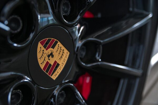 A close up of the wheel rim with a porsche logo on it.