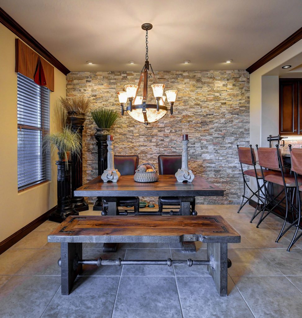 A dining room with stone walls and a table