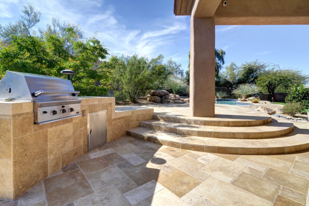 A patio with steps leading to the outdoor kitchen.