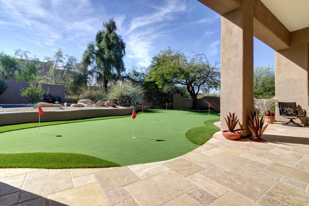 A view of a backyard with a putting green.