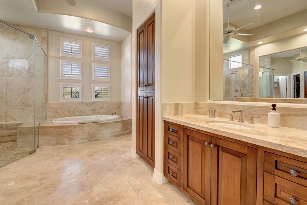A bathroom with a large tub and wooden cabinets.