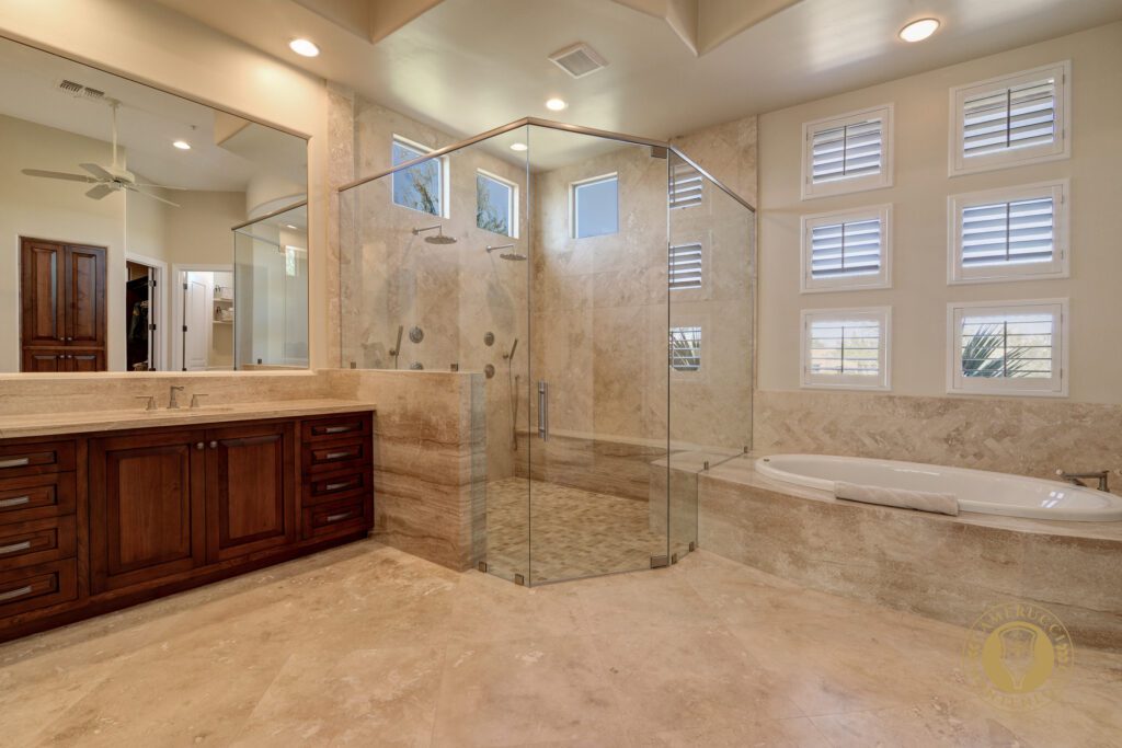 A large bathroom with a walk in shower and a double sink.