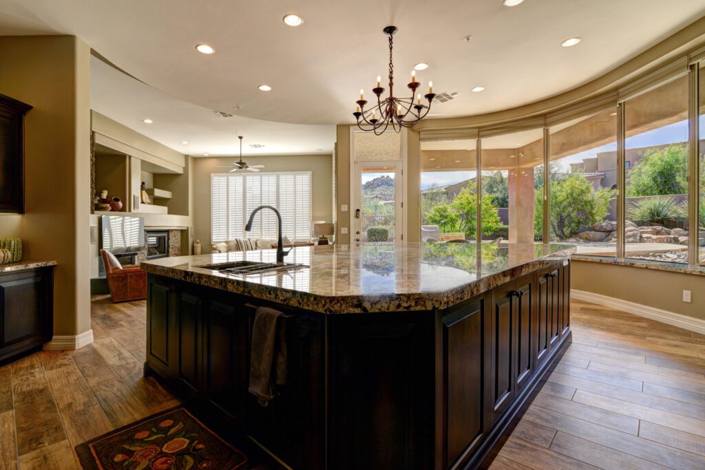 A kitchen with a large island and granite counter tops.