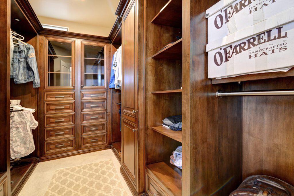A large wooden closet with many drawers and shelves.