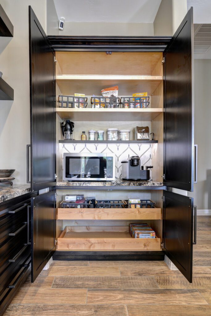 A kitchen with an open cabinet and shelves.