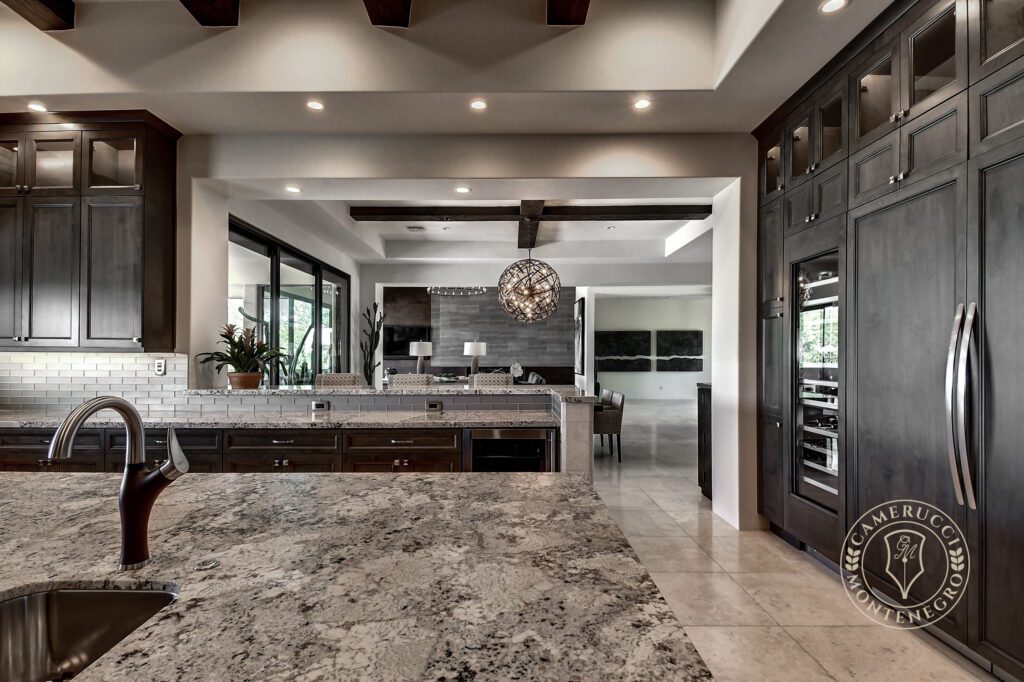 A large kitchen with marble counters and a wine fridge.