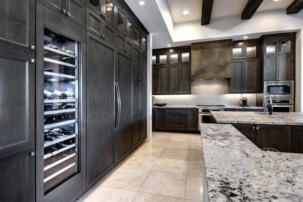 A kitchen with dark cabinets and a wine cooler.