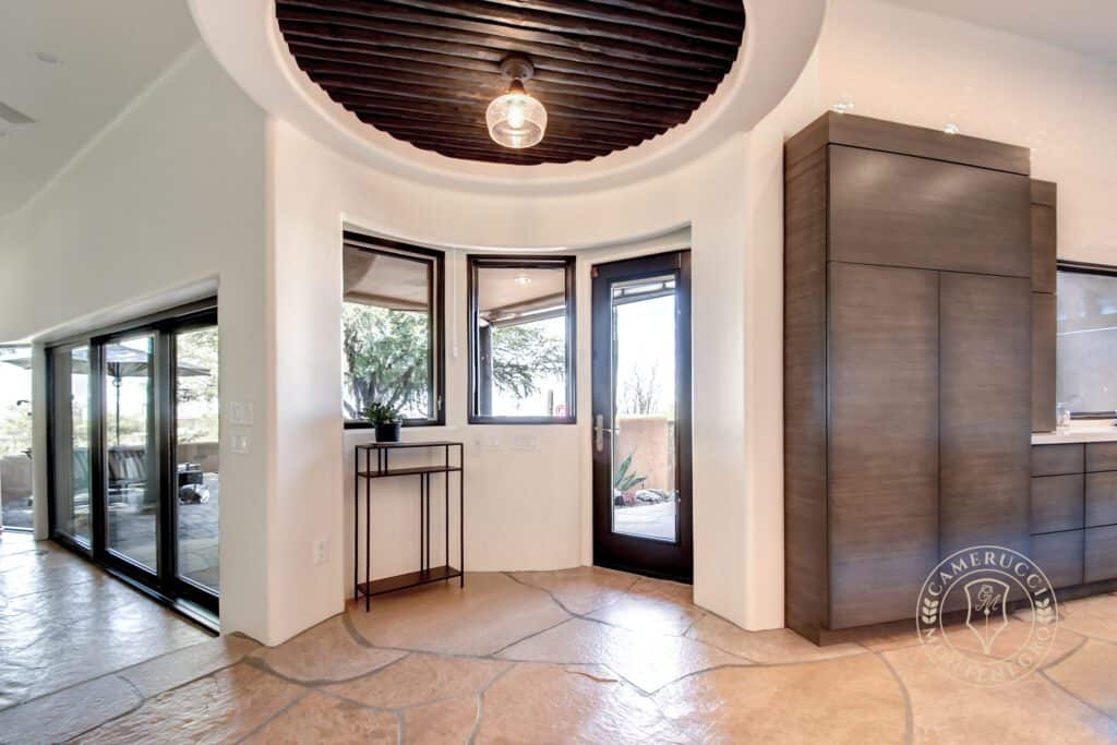 A room with a round window and a wooden ceiling.