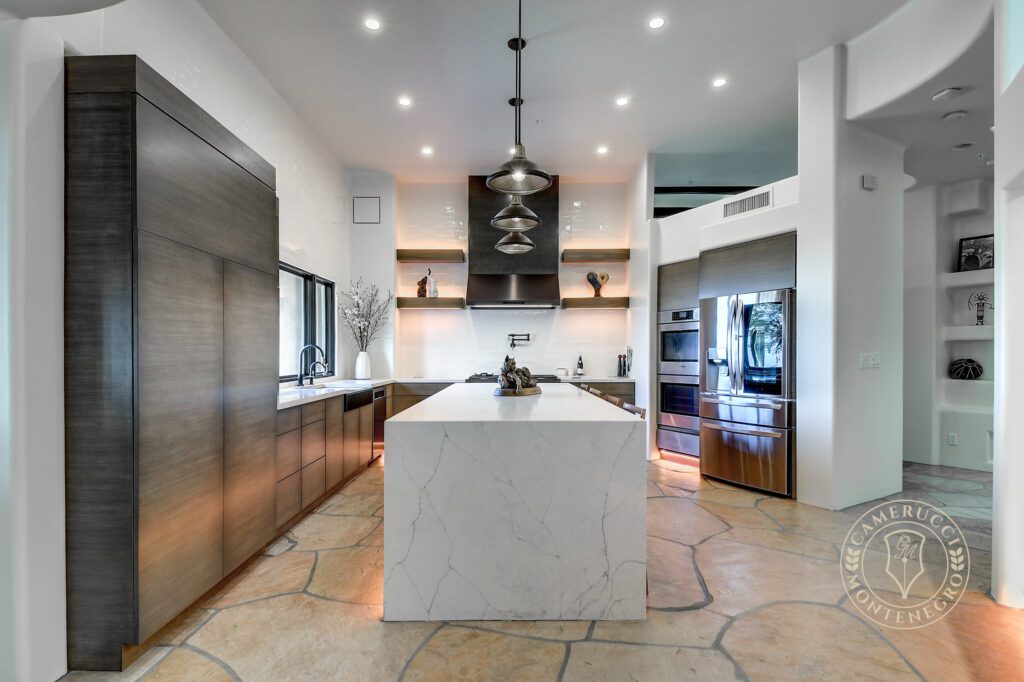 A kitchen with a large island and stainless steel appliances.