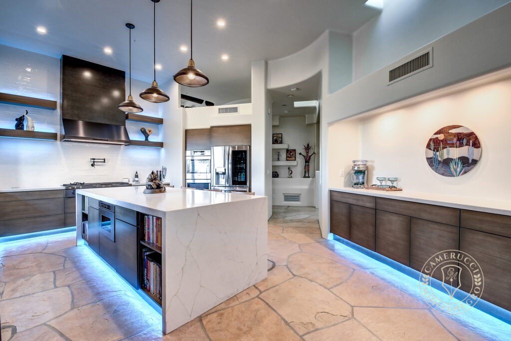 A kitchen with a large island and a lot of lighting