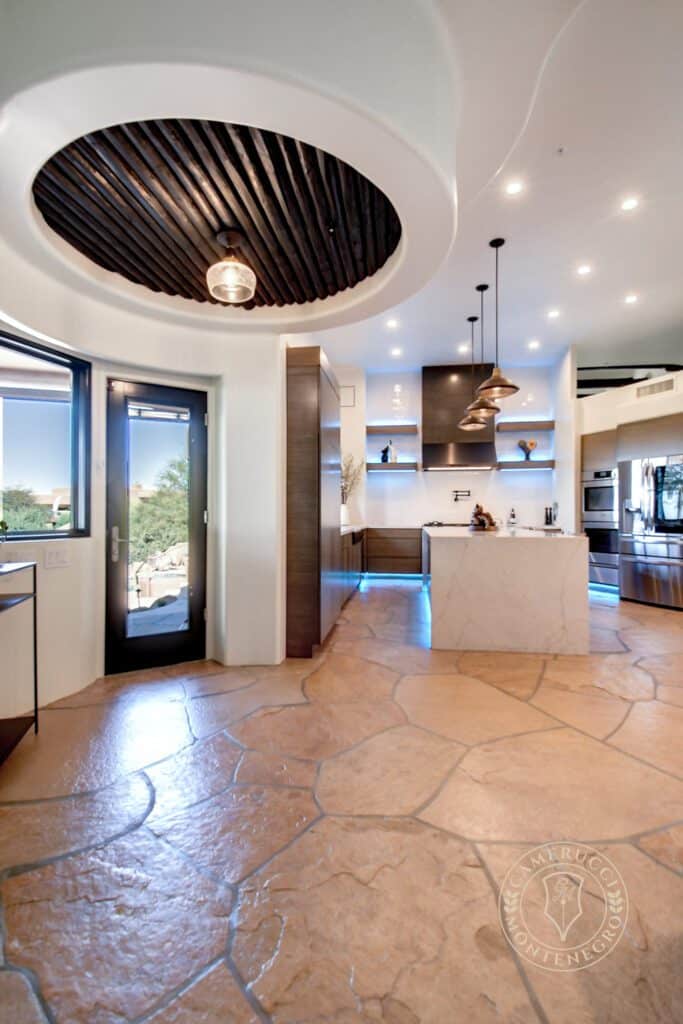 A kitchen with a large island and tiled floors.